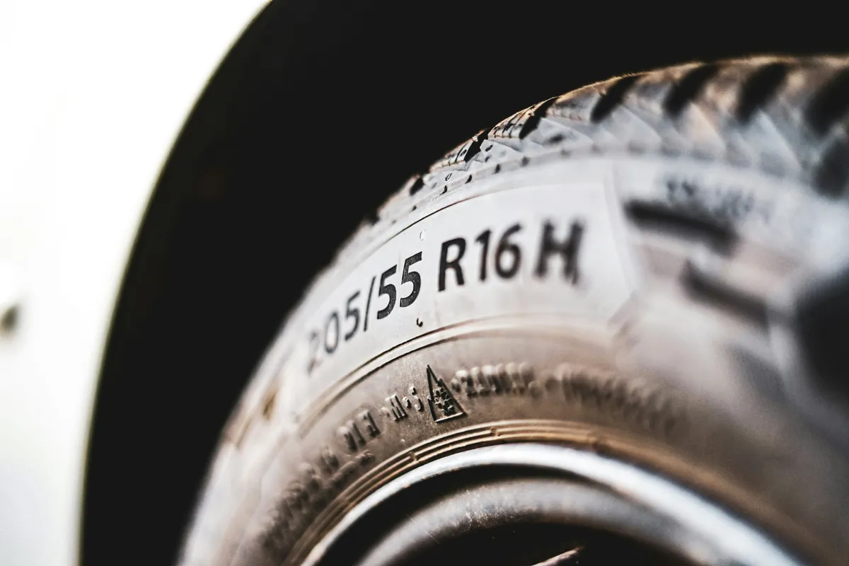Gros plan sur le flanc d'un pneu, où la dimension 205/55 R16 est gravée en relief